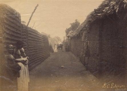 View along a street in the royal quarter of Benin City, 1897. Photograph from The British Museum